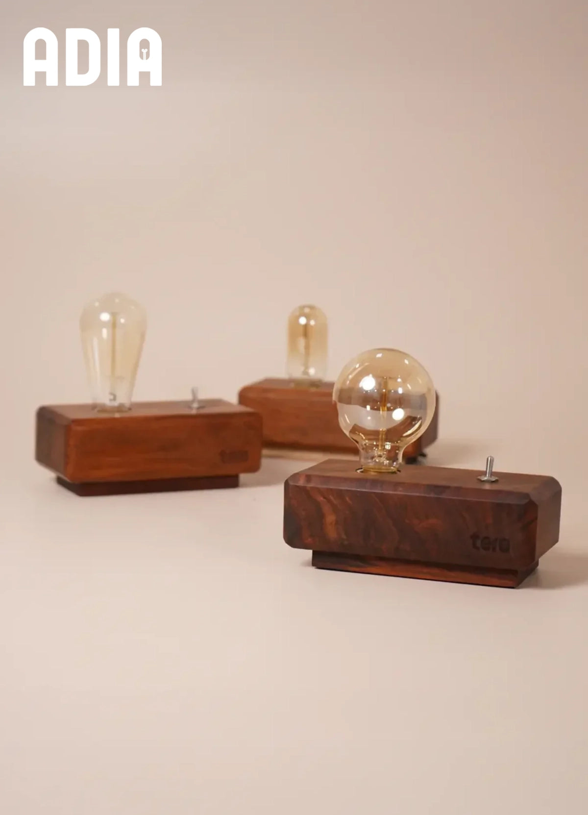 ADIA solid wood desk lamp with diamond-cut Sheesham body and warm Edison bulb glow on a desk