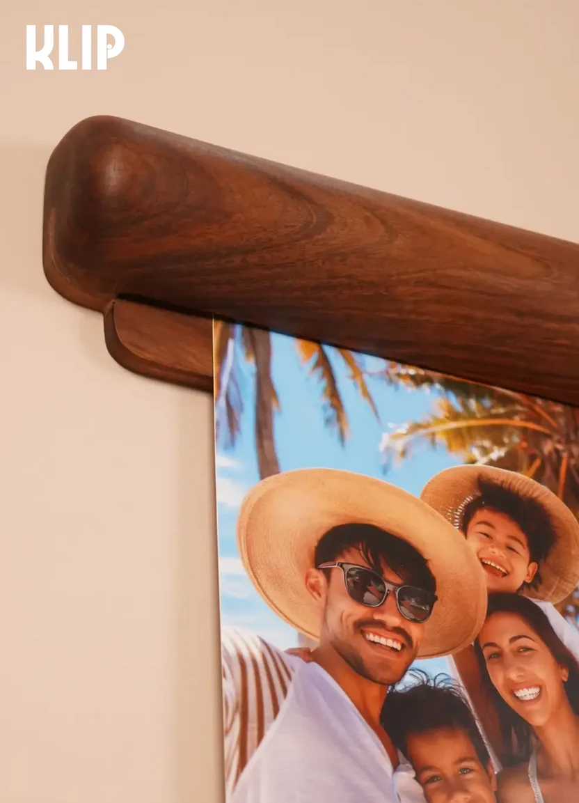 KLIP wall-mounted solid wood paper display frame holding an art print on a living room wall